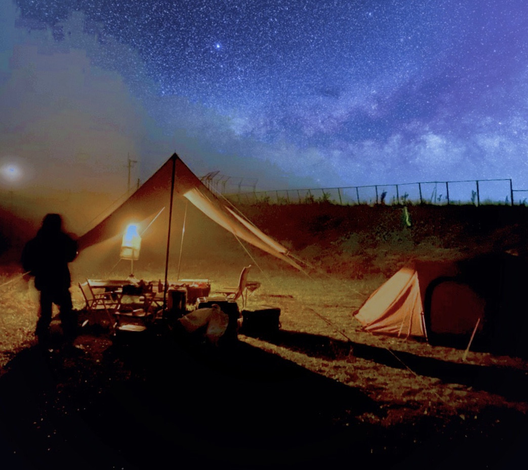 夜空の下でキャンプをする写真